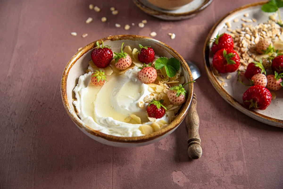 Skål med yoghurt, jordgubbar och havregryn på ett bord
