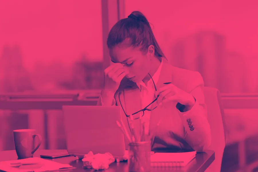 The moment the load shows — head in hands at the desk